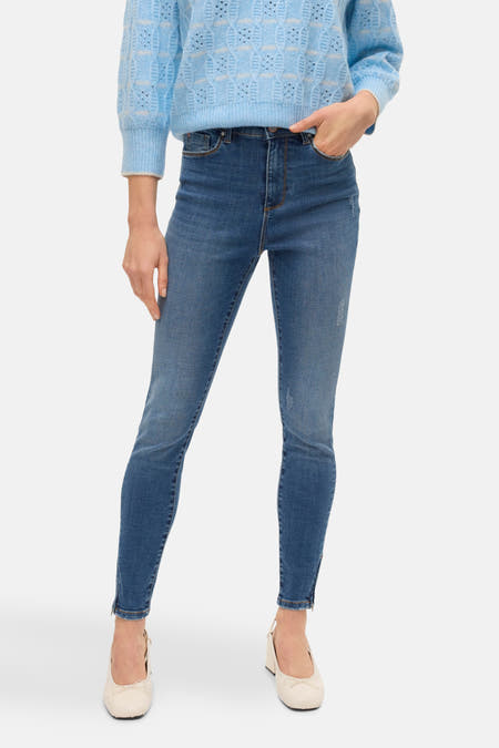 T-shirt bleu avec col rond de VERO MODA, porté avec un pantalon en cuir et des escarpins.