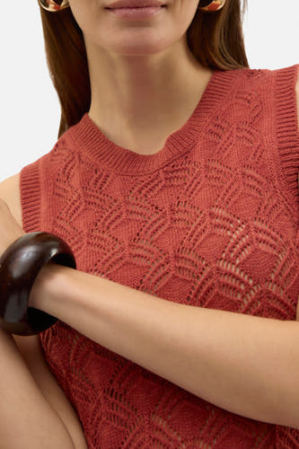 Robe sans manches de Vero Moda, avec un motif de broderie ouvert, portée avec des boucles d'oreilles dorées et un bracelet marron foncé.