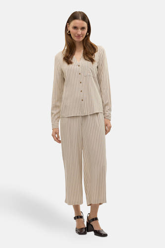 Beige overhemd met lange mouwen van VERO MODA®, met krijtstrepen en een borstzak, gedragen met gestreepte broek en zwarte schoenen.