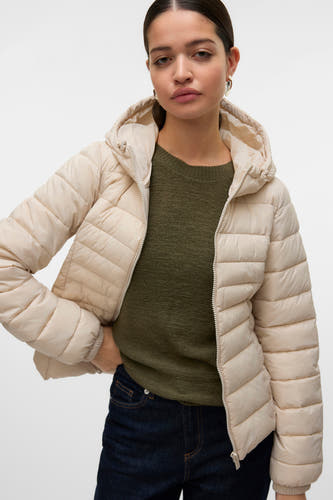 Gilet écru de Vero Moda avec capuche, porté sur un pull vert et des jeans foncés.