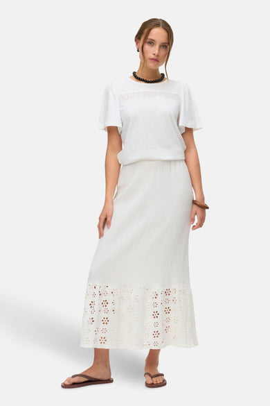 Blouse blanche à manches courtes de VERO MODA, finie avec des détails de broderie sur le devant.