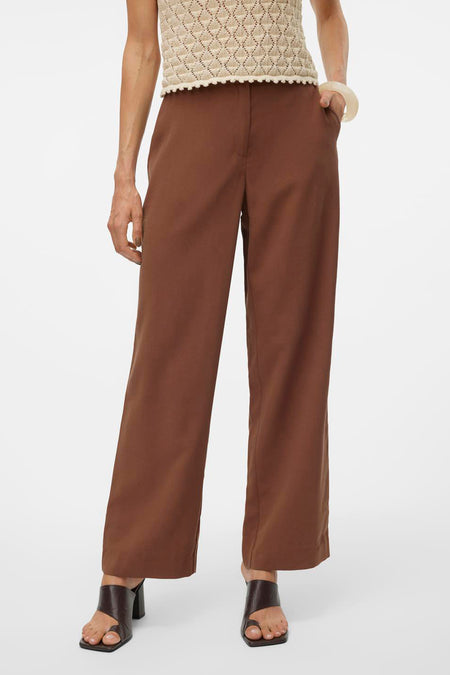 Pantalon marron de VERO MODA, à jambes larges et porté avec un haut en maille beige et des sandales marron.