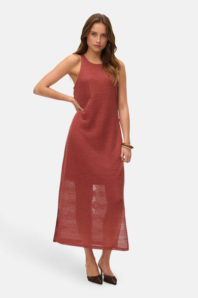 Robe sans manches de Vero Moda en couleur rouge avec une texture tricotée et un déchiré, portée avec des bottes marron.