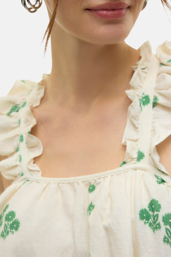 Blouse écru sans manches de Vero Moda avec un motif de fleurs vertes et des détails plissés.