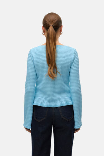 T-shirt bleu à manches longues de VERO MODA, avec une texture unique, vu de derrière, associé à des jeans foncés.