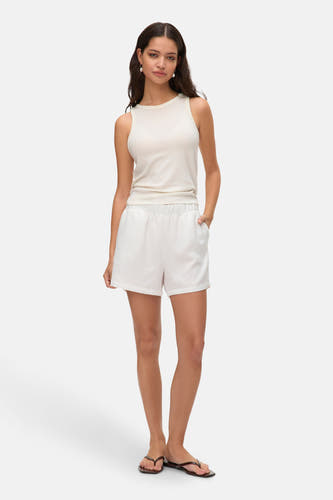 Witte korte broek van VERO MODA, gecombineerd met een mouwloze top en sandalen, staand op een witte achtergrond.
