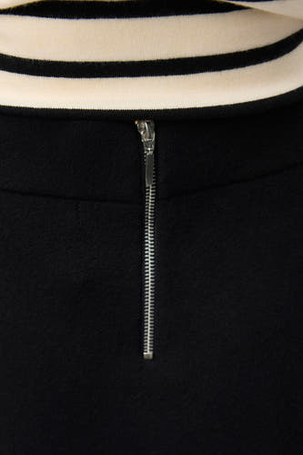 Jupe courte noire de VERO MODA, avec une fermeture éclair argentée à l'arrière et un haut rayé.