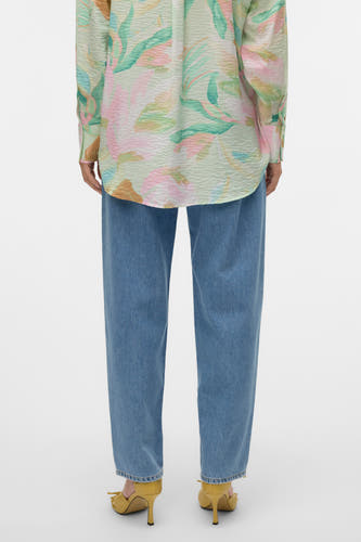 Jean en denim bleu spécial fit de VERO MODA, associé à une chemise à imprimé floral et des baskets jaunes.