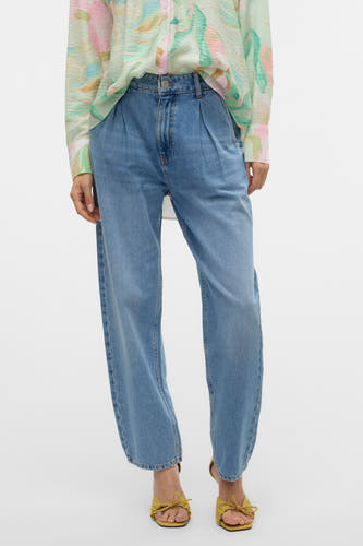 Jean special fit de denim bleu de VERO MODA, avec des plis à l'avant, associé à une robe imprimée.
