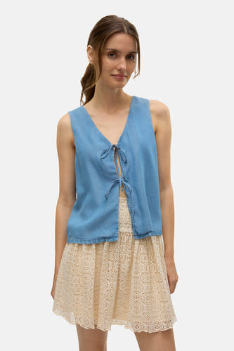 Blouse bleue de VERO MODA, avec détail rayé sur l'avant et associée à une jupe en dentelle.