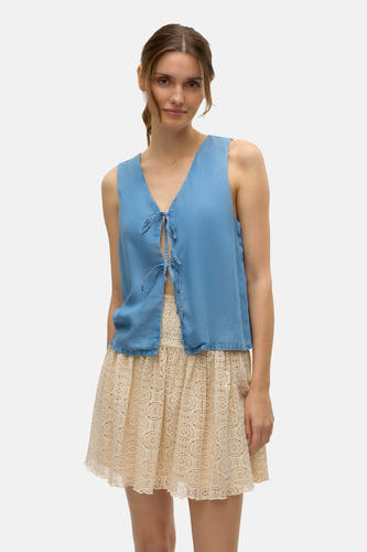 Blouse bleue de VERO MODA avec détail de boutons et une jupe en dentelle beige.