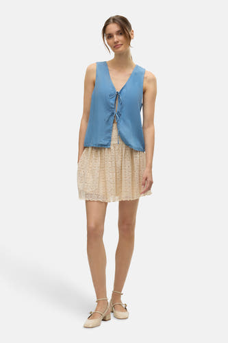 Blouse bleue de VERO MODA®, avec détail rayé et associée à une jupe en dentelle beige et des chaussures Mary Jane.