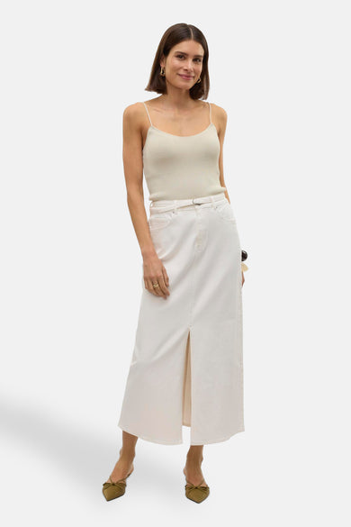 Long manteau blanc de VERO MODA, avec une fente à l'avant, associé à un top spaghetti et des talons bas.