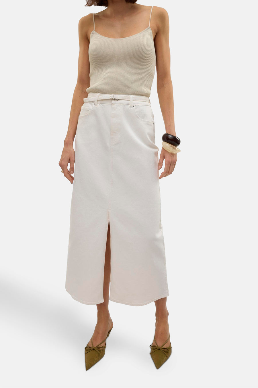 Robe longue blanche de Vero Moda, avec une fente à l'avant, portée avec un haut et des bottes.