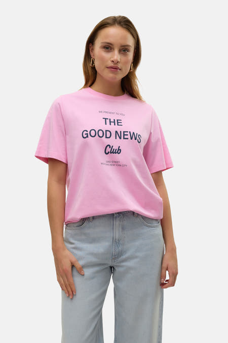 T-shirt rose à manches courtes de VERO MODA®, avec impression textuelle et associé à un jean bleu clair.