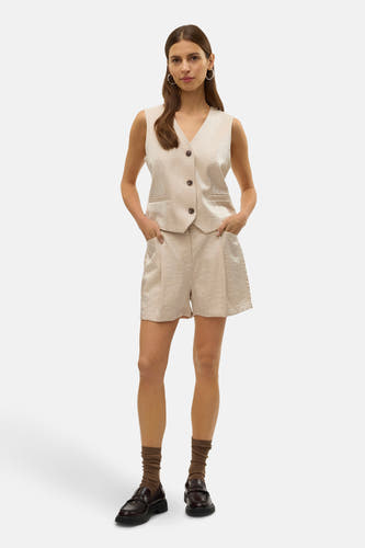 Short écru de VERO MODA, associé à un gilet coordonné, des chaussettes brunes et des loafers noirs.