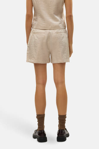 Crème court de VERO MODA, avec une subtile texture, associé à des chaussettes et des chaussures brunes, vu de derrière.