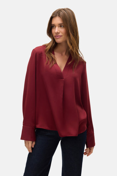 Blouse rouge à manches longues de VERO MODA, portée avec un short en jean foncé.