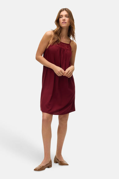 T-shirt sans manches de Bordeaux de Vero Moda, avec des détails de bordure au col, porté avec des chaussures marron.