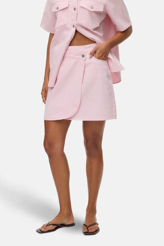 Robe courte rose de Vero Moda, avec détail de pli et poche à boutonnière, associée à un chemisier rose.