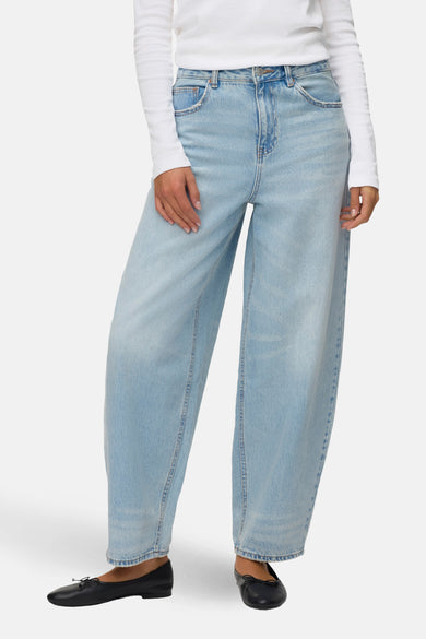 Jean en denim bleu clair de VERO MODA, à jambes larges et combiné avec une chemise blanche et des ballerines noires.
