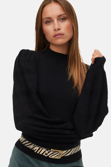 Sweat-shirt noir à col rond de VERO MODA, avec des détails décoratifs sur les manches, associé à une ceinture imprimée zèbre.