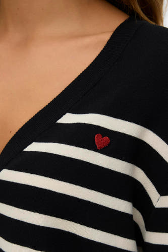 Gilet noir de VERO MODA® avec des rayures blanches et un petit cœur rouge brodé.