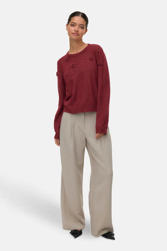 Pull rouge à col rond de VERO MODA, orné de roses, associé à un pantalon large et des chaussures noires.