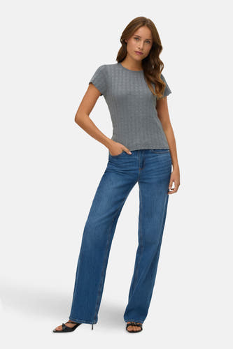 T-shirt gris à manches courtes de VERO MODA, porté avec des jeans bleus et des baskets noires.