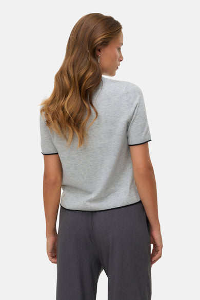 Sweat-shirt gris avec col rond de VERO MODA, vu par derrière, avec une bretelle noire et des longs cheveux détachés.