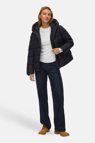 Zwarte korte jas van VERO MODA, gedragen met een wit shirt, donkerblauwe jeans en bruine veterschoenen.