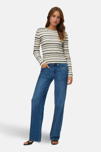 T-shirt blanc à col rond de VERO MODA, avec des rayures horizontales noires, porté avec un jeans bleu et des sandales noires.