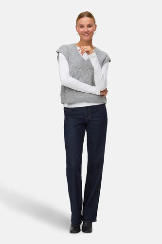 Gilet gris de VERO MODA, avec un motif côtelé, associé à une chemise blanche à manches longues et des jeans foncés.
