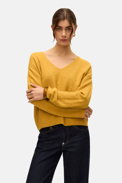 Pull à col V en vert de VERO MODA, associé à des jeans foncés et des chaussures marrons.