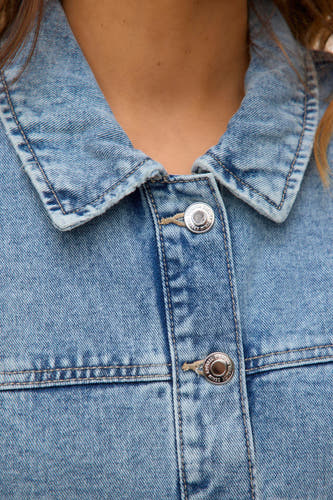 Kort, lichtblauw denim jasje van Vero Moda, met zilverkleurige knopen en stiksels.
