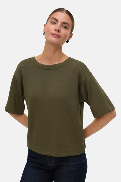 T-shirt vert de mantes courtes cour V V VA, avec un col rond et porté avec des jeans foncés.