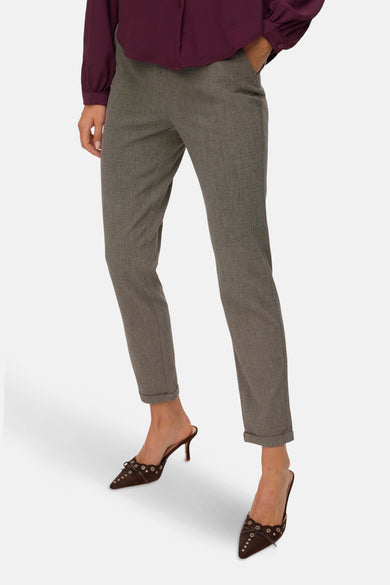 Pantalon brun de VERO MODA, avec une subtile texture et des jambes pliées, combiné à des mocassins bruns et une blouse bordeaux.