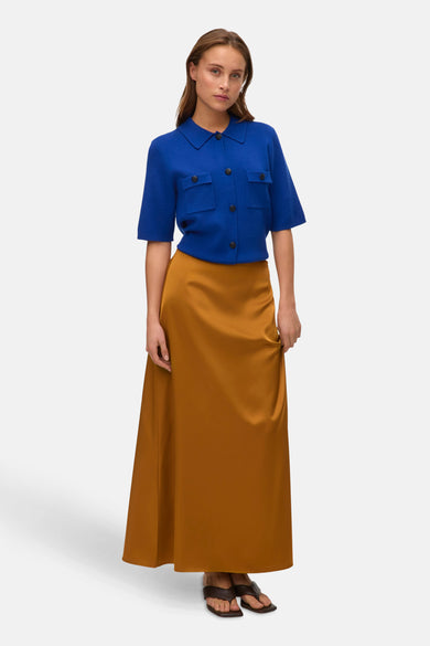 Robe longue dorée de VERO MODA, associée à une blouse bleue et des sandales.