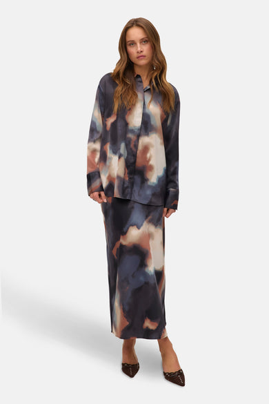 Chemise multicolore à manches longues de VERO MODA, avec imprimé abstrait, portée avec une longue jupe et des chaussures marron.