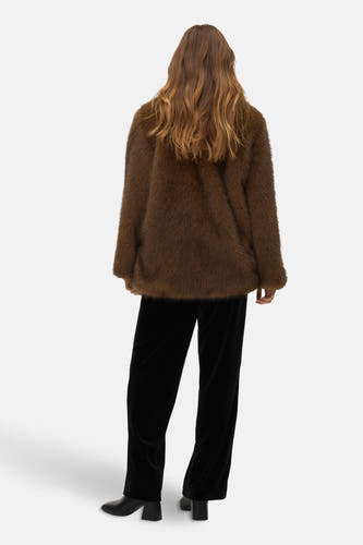 Manteau court brun de VERO MODA, vu par derrière, avec une jupe en velours noir et des bottes en cuir.