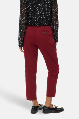 Jean rouge VERO MODA avec une poche à bouton, associé à une chemise rayée noir et blanc et des loafers noirs.