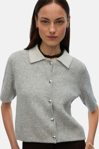 Gilet gris de VERO MODA, avec des manches courtes, un col et une fermeture à boutons, associé à une chaîne noire.