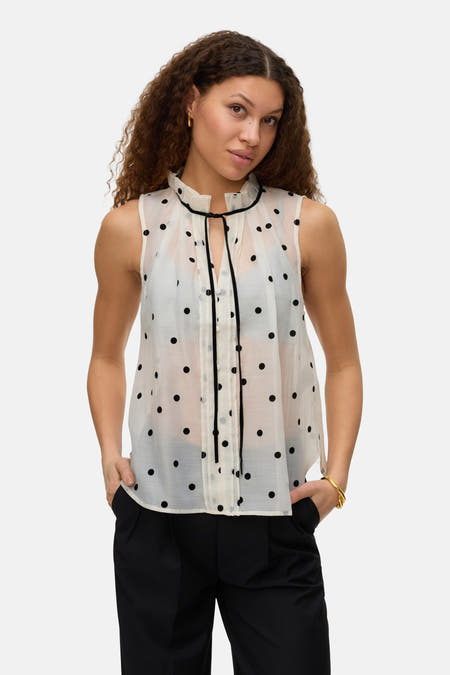 Chemise beige à manches courtes de VERO MODA, avec un motif à carreaux, associée à une jupe noire.