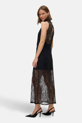 Robe sans manches noire de VERO MODA, avec des détails transparents et de petits strass, montrée en biais.