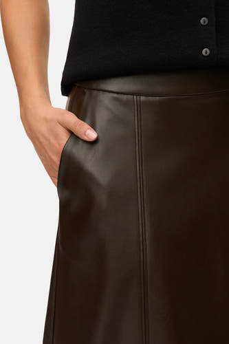 Long manteau brun de VERO MODA, avec une texture en cuir et une poche sur la main.