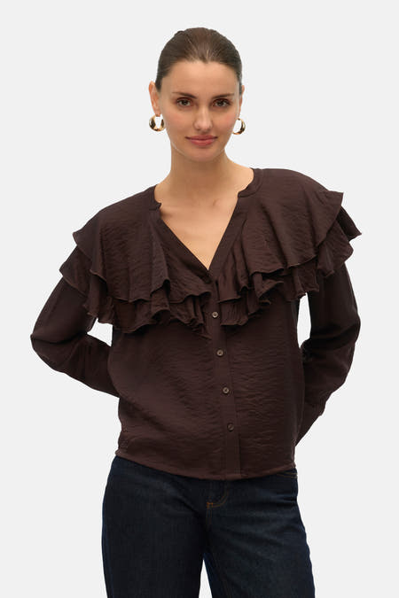 Chemise brune à longues manches de Vero Moda, avec des plis sur le devant et un jeans foncé.