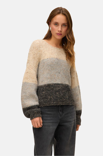 Gilet beige à col rond de VERO MODA, avec un design rayé et des manches longues, porté avec un jean noir.