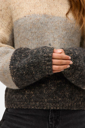 Sweat-shirt beige avec col rond de Vero Moda, avec des poches et des manches longues, porté avec des jeans noirs.