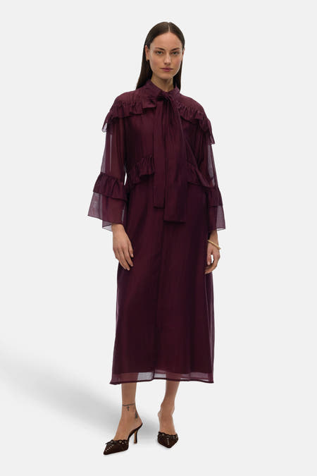 Robe noire avec des manches longues de VERO MODA, avec des plis et des détails en côtes, portée avec des bottes marron.