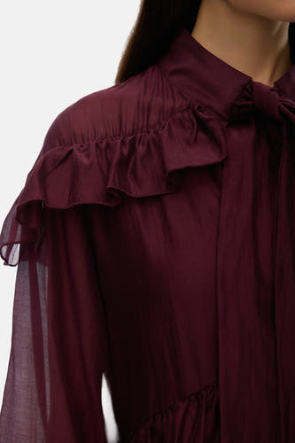 Manteau marron à longues manches de Vero Moda, avec un collier au cou et des volants sur les épaules.